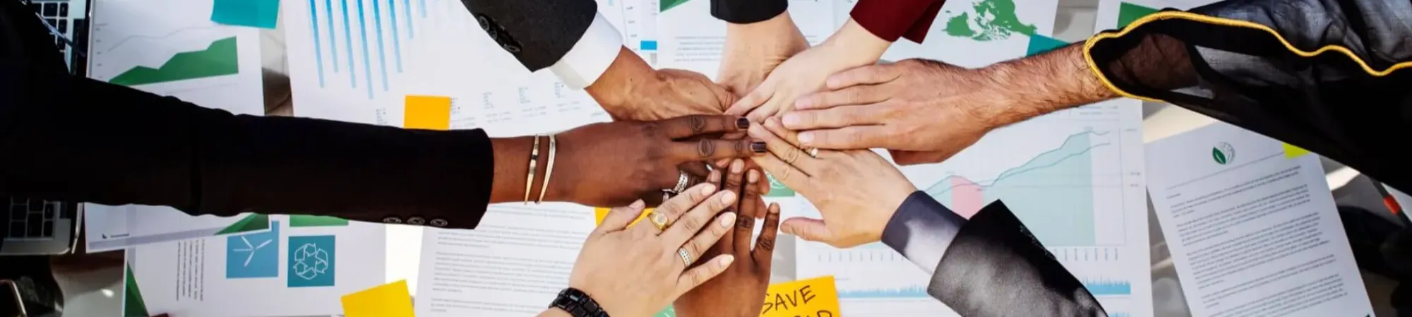 Diverse group of co-workers joining hands