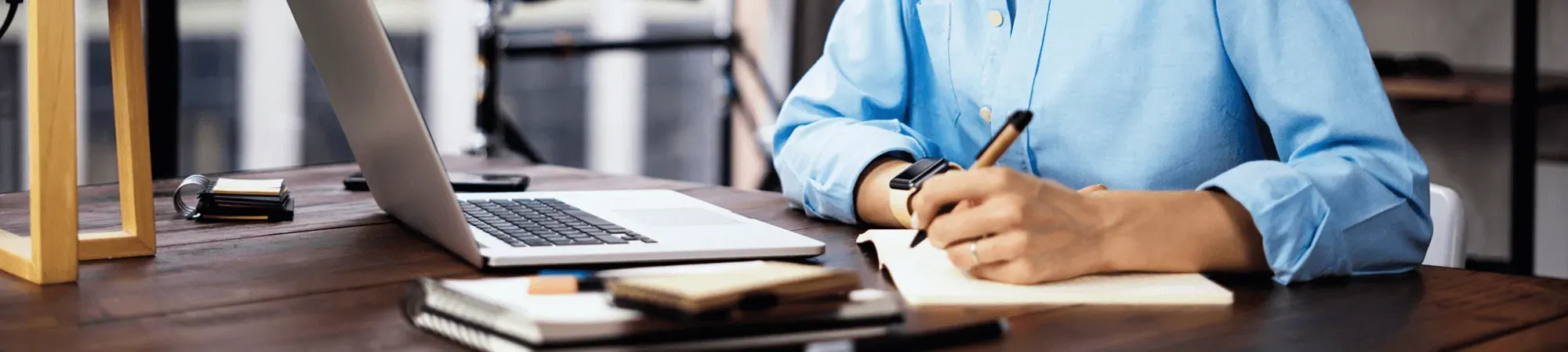 Author writing in front of laptop