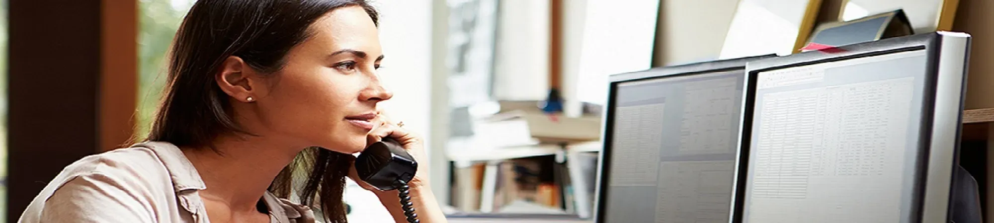 Woman accepting telephone call at desk